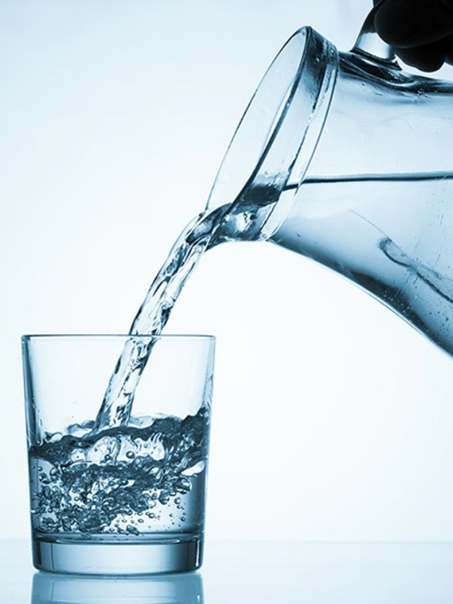 A man is pouring the water into a glass.