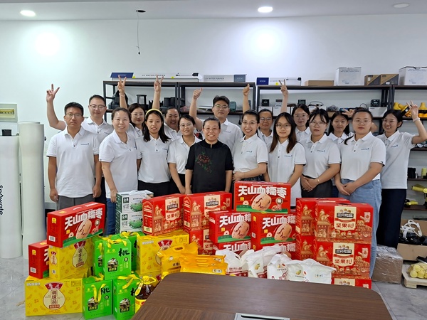 Employees commemorate the dual festivals by taking photos with festival gifts at the company.