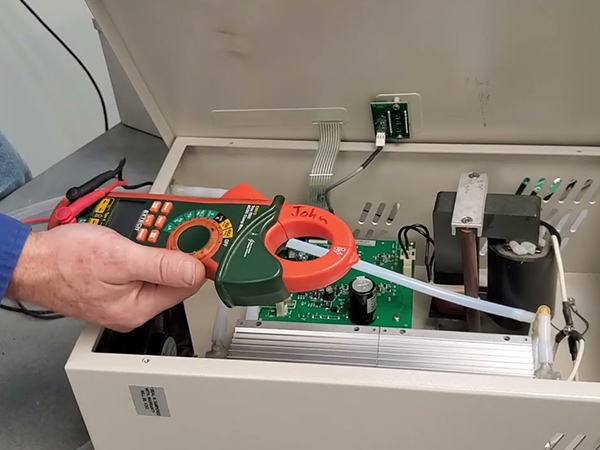 The worker is conducting fault detection on the ozone generator